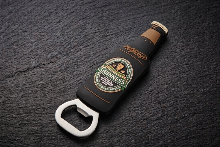 Guinness bottle opener on a dark surface