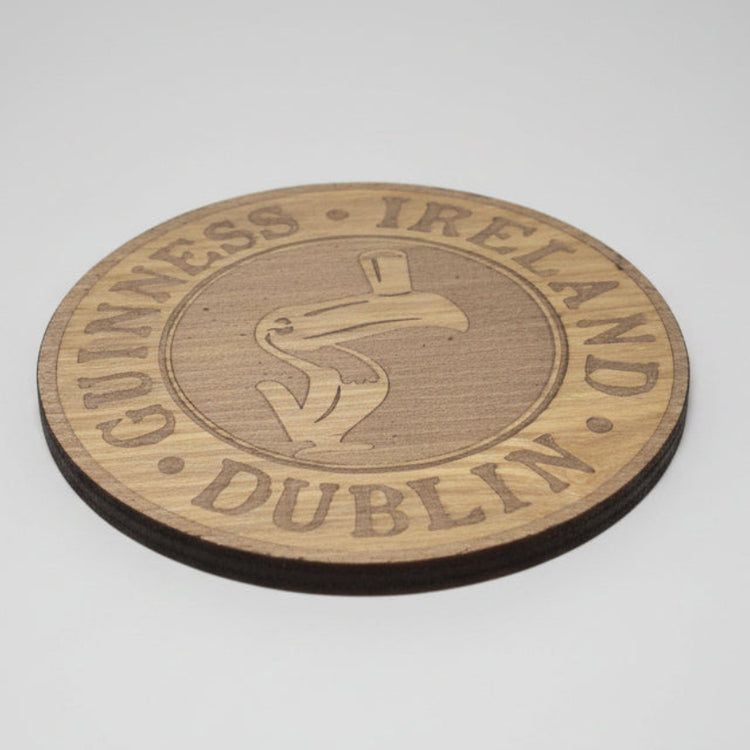 Wooden coaster with Guinness Ireland Dublin branding on a dark background