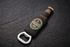 Guinness bottle opener on a dark surface