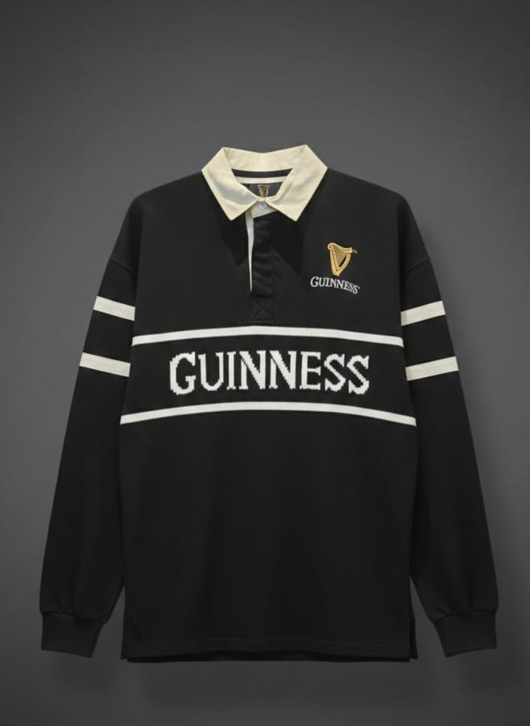 Black rugby shirt with white stripes and 'Guinness' branding on a gray background