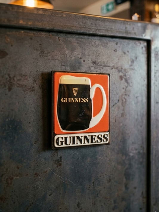 Guinness logo on a metal surface in a bar setting
