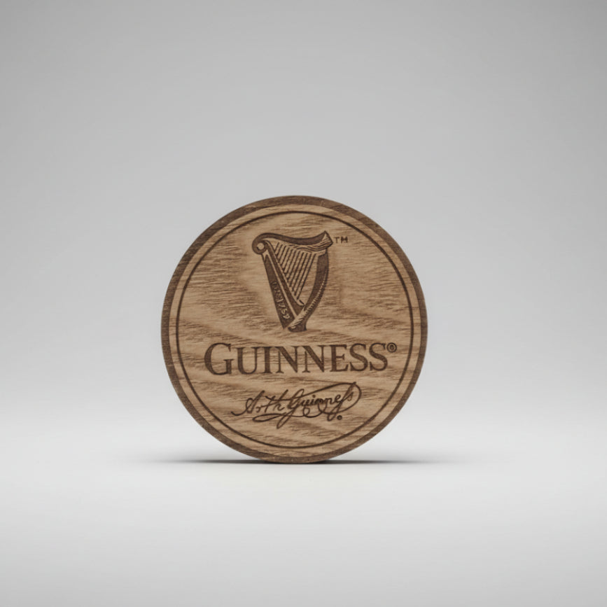 Wooden coaster with Guinness logo on a dark background